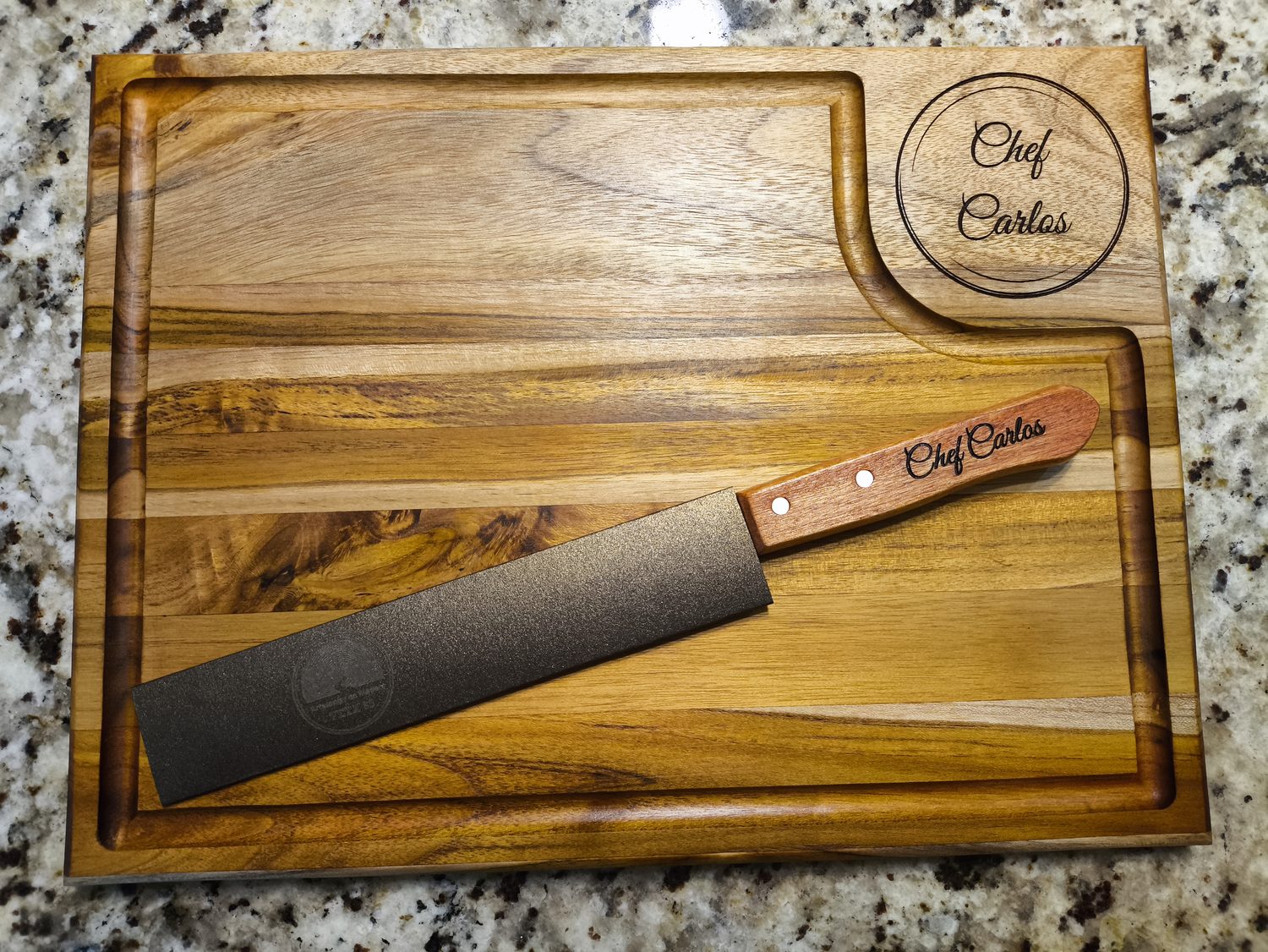 Tabla con el nombre Chef Carlos grabado en un medallón y cuchillo a juego
